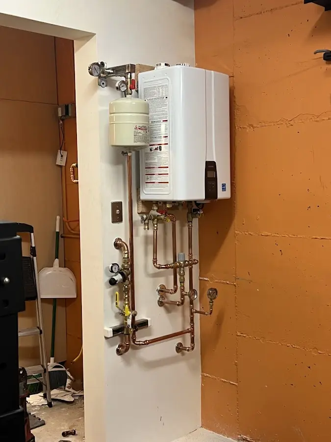 Plumbing technician inspecting water heater connections in Southchase